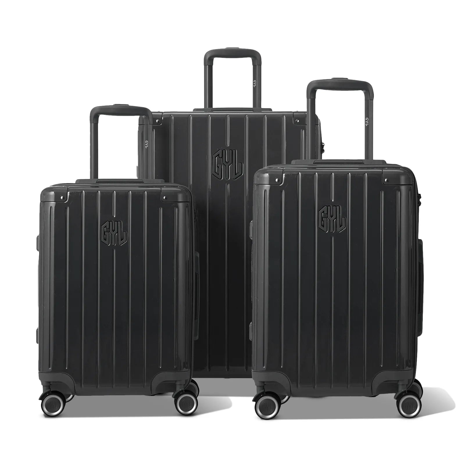 Trois valises rigides GYL Intemporelle gris foncé, format cabine et soute, avec poignée trolley déployée.