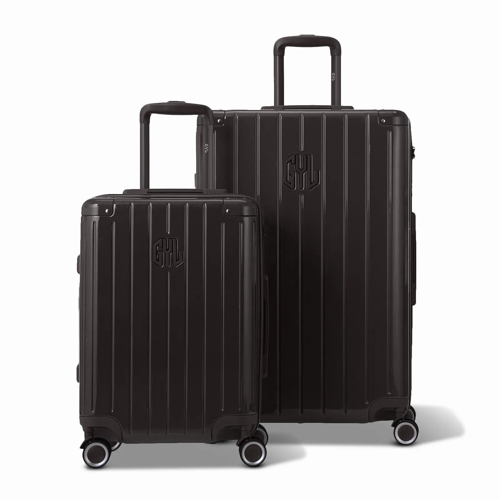 Deux valises rigides GYL Intemporelle noir, 2 formats, avec poignée trolley déployée.