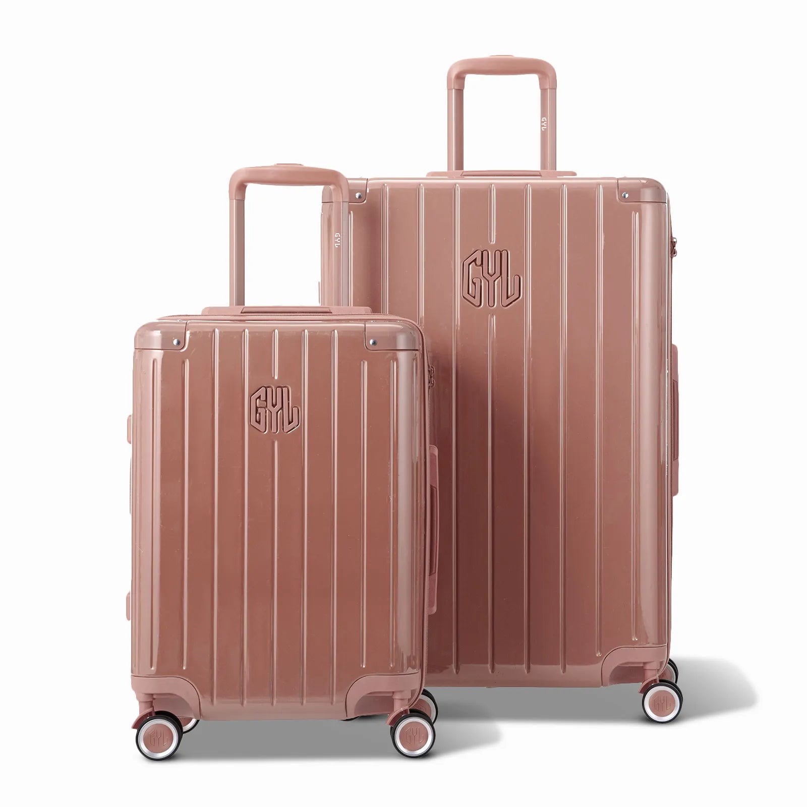 Deux valises rigides GYL Intemporelle rose gold, format cabine et soute, avec poignée trolley déployée.