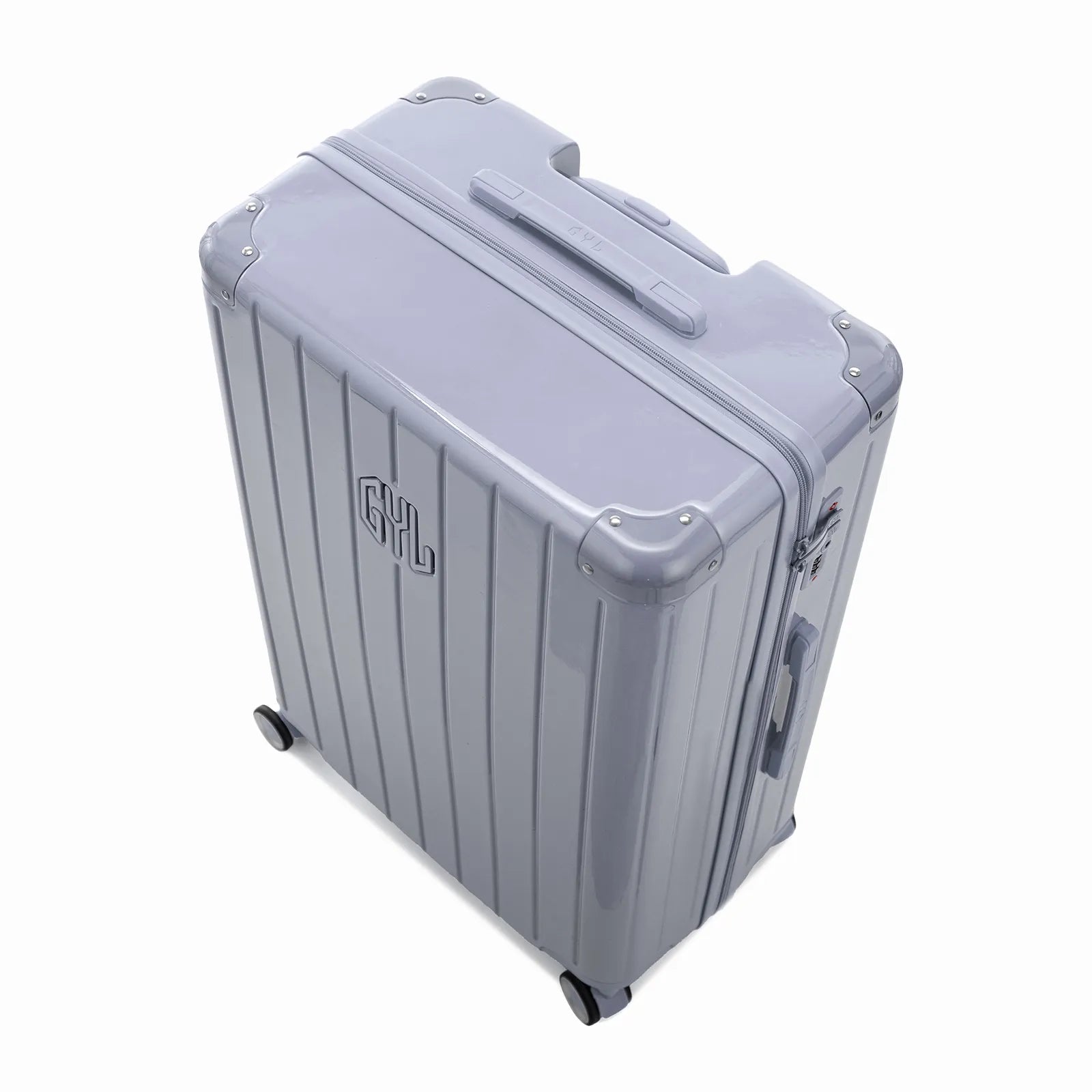 Vue en angle de la valise rigide GYL Intemporelle argent avec coins renforcés et coque nervurée brillante.