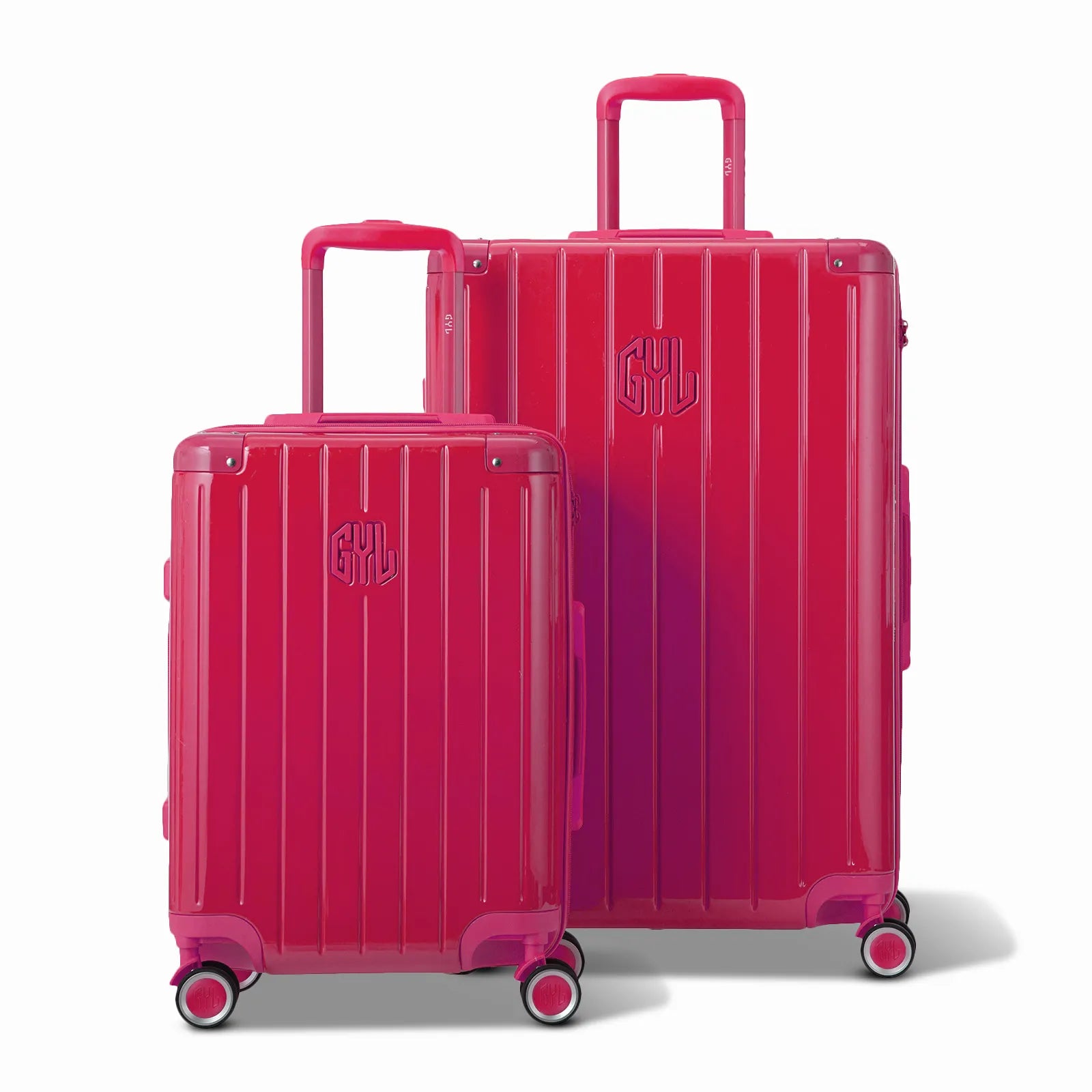 Deux valises rigides GYL Intemporelle fuchsia, format cabine et soute, avec poignée trolley déployée.