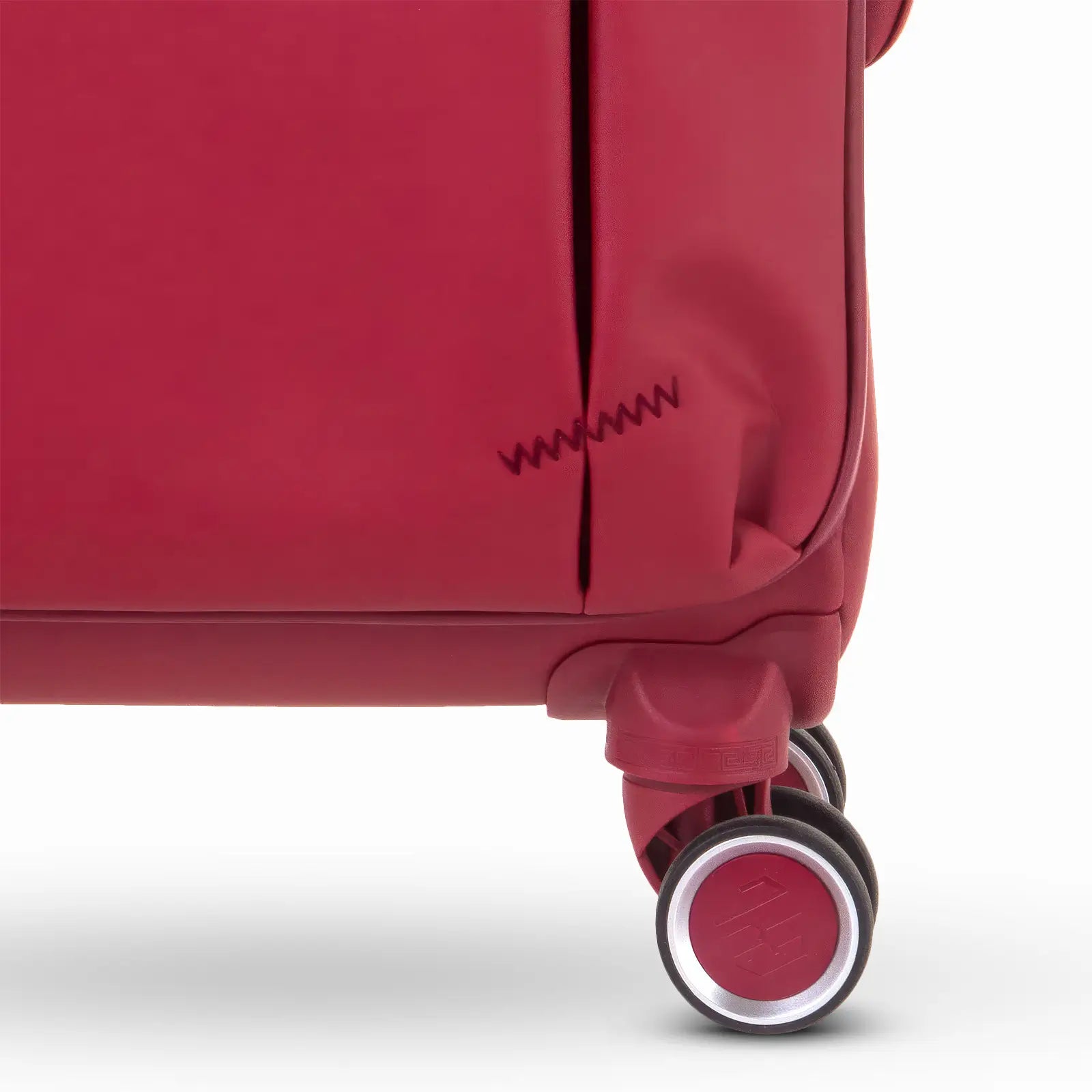 Gros plan sur les roues doubles rouges de la valise Évasion GYL, dotées d’un revêtement antibruit pour une glisse fluide et silencieuse sur toutes les surfaces.