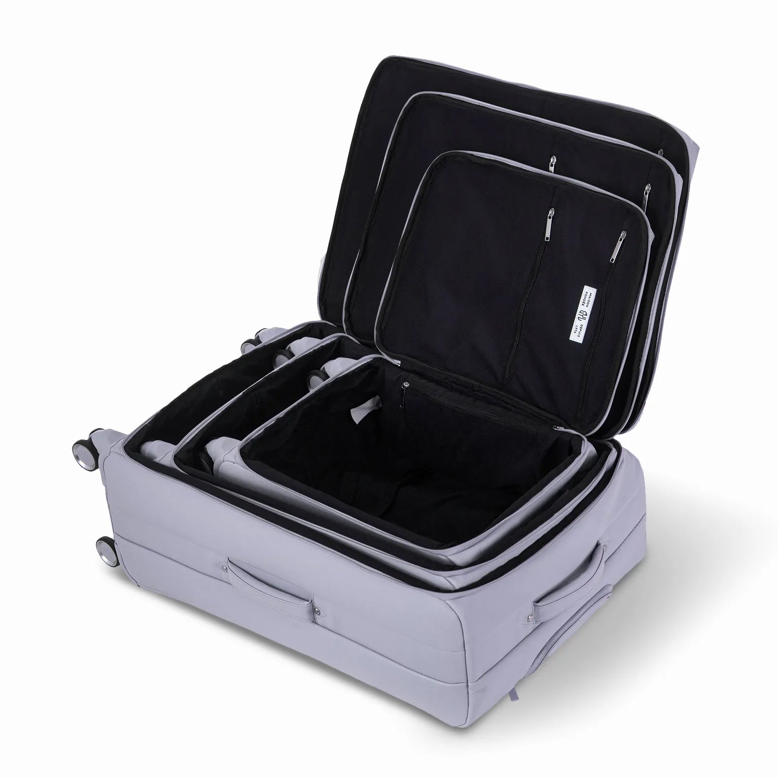 Ensemble de trois valises GYL Évasion en polyuréthane argent, ouvertes et imbriquées les unes dans les autres pour montrer leur conception pratique et leur intérieur spacieux.