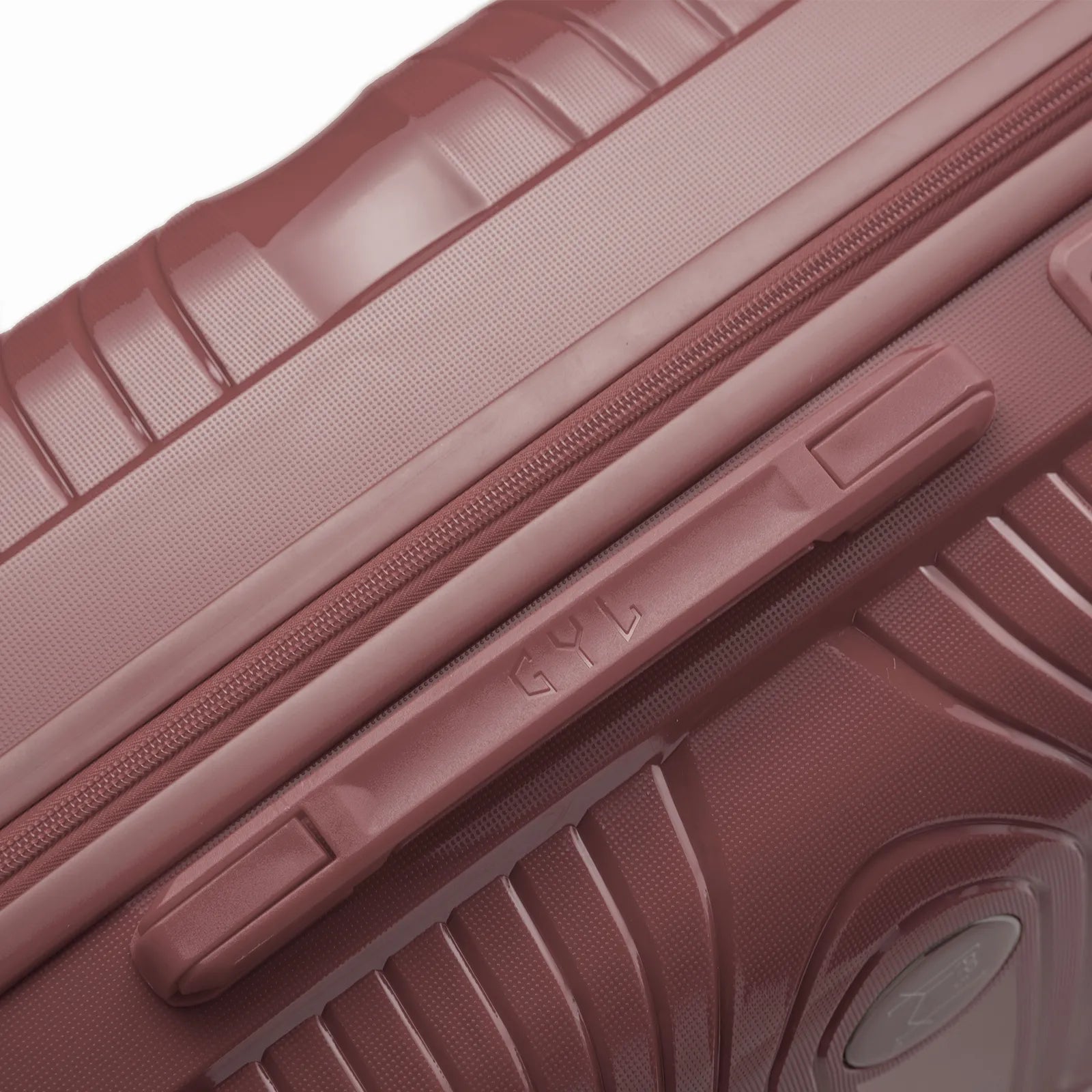 Détail de la poignée latérale et du logo GYL sur la valise Signature rose gold.