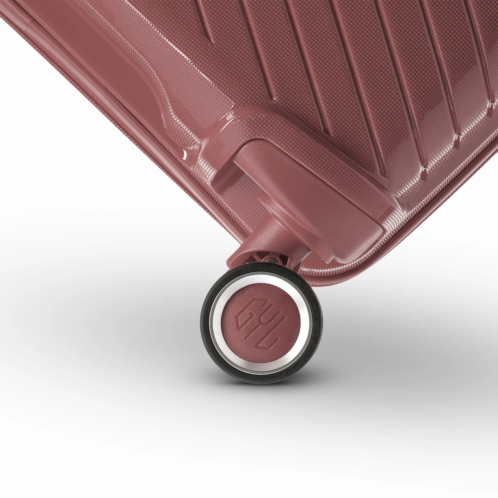 Détail de la roue avec logo GYL sur la valise Signature rose gold en polypropylène brillant.
