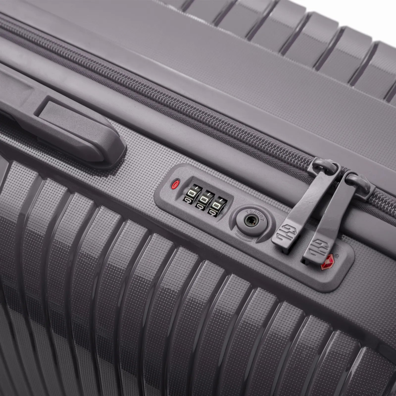 Détail de la serrure TSA intégrée et des curseurs sur la valise Signature argent.