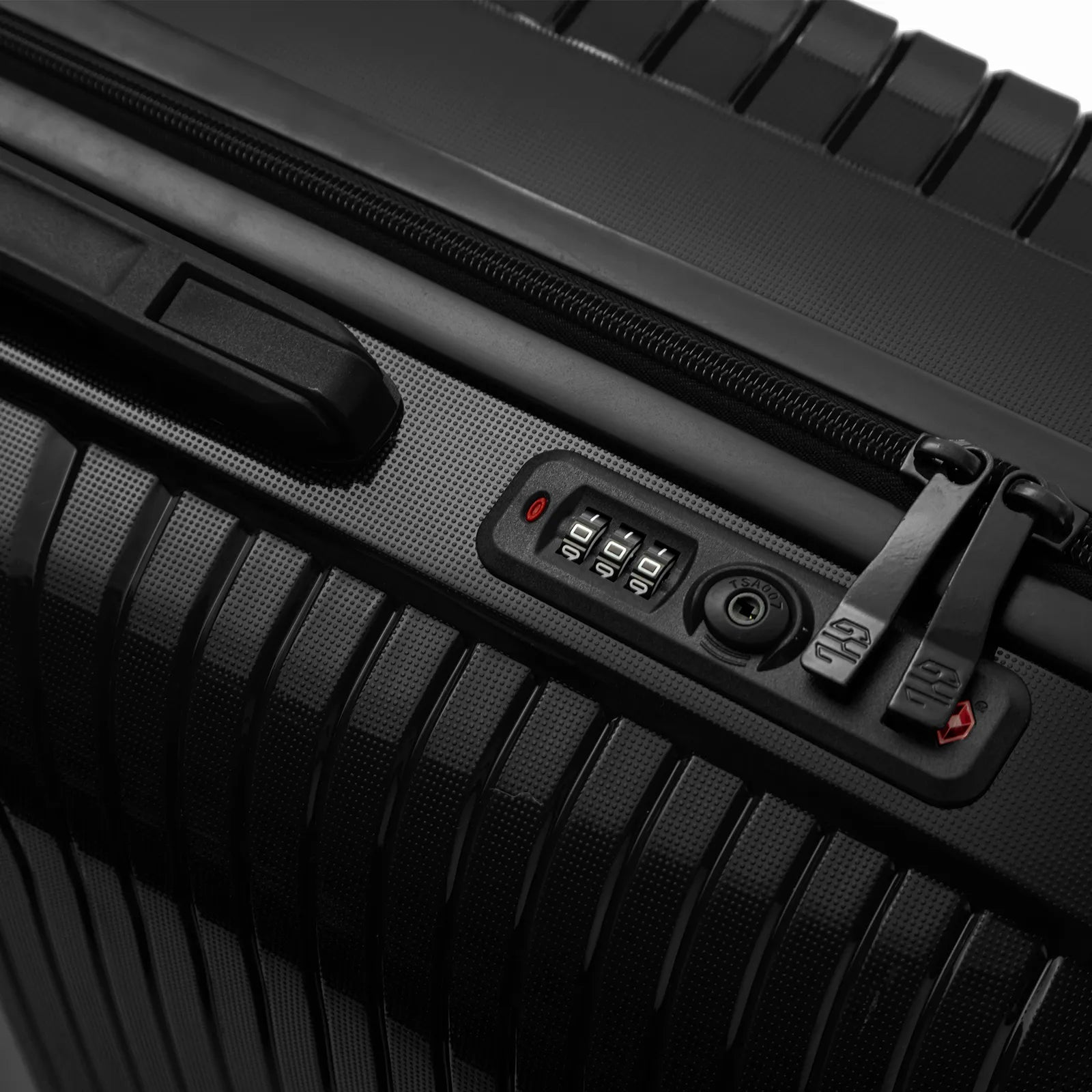 Détail de la serrure TSA intégrée et des curseurs sur la valise Signature noire.