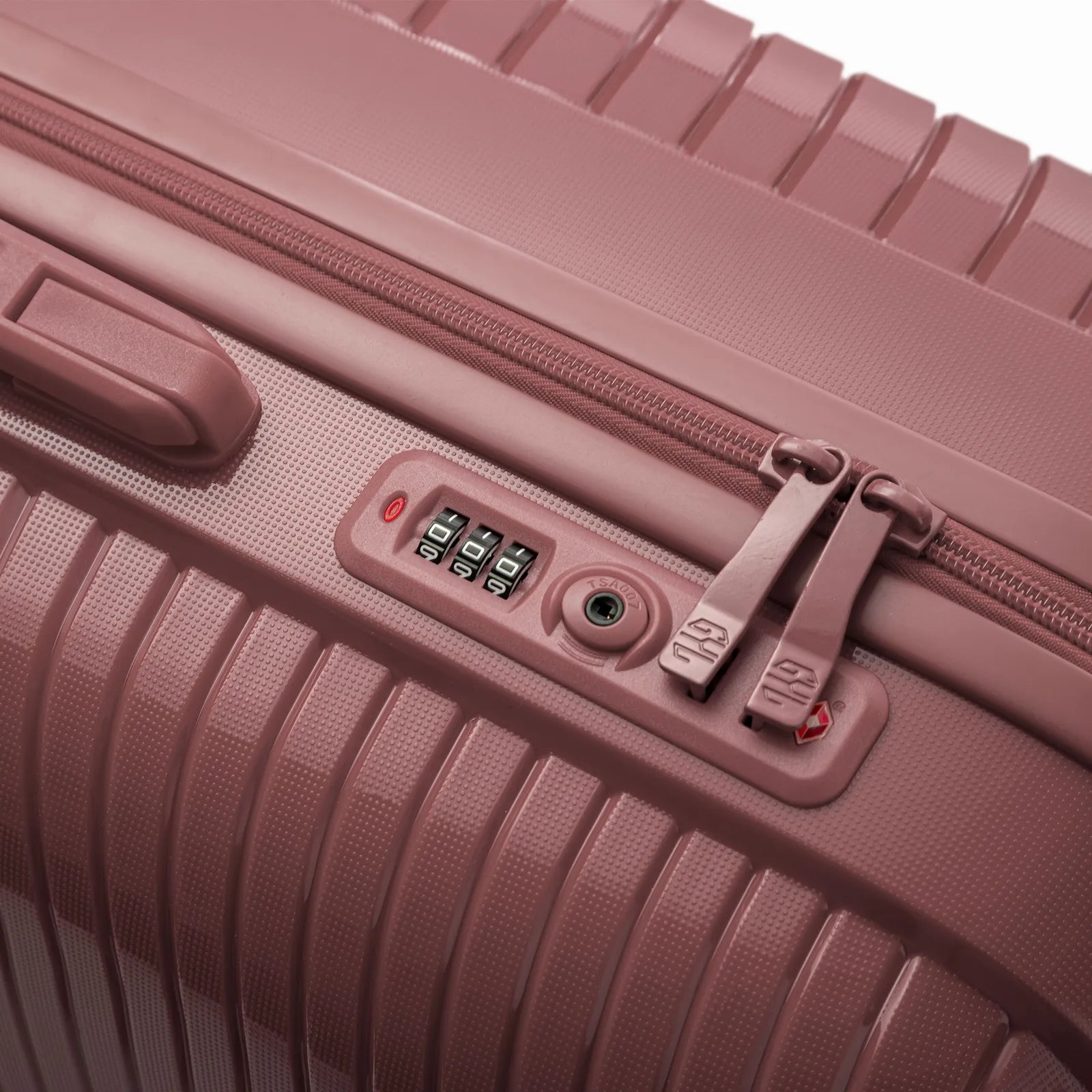 Détail de la serrure TSA intégrée et des curseurs sur la valise Signature rose gold.