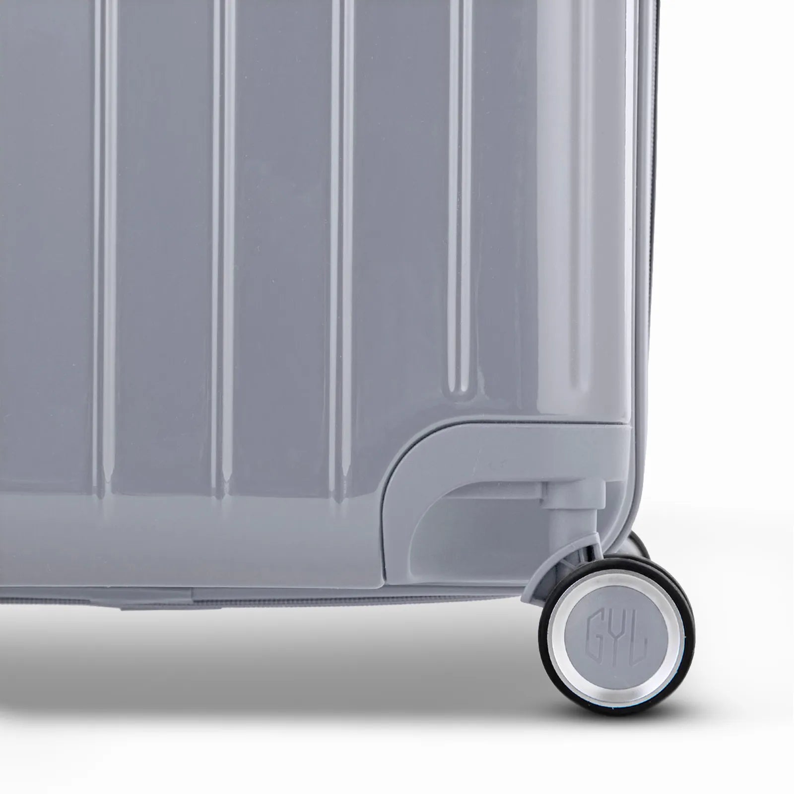 Détail de la roue et du logo GYL sur le bas de la valise trunk argent en polycarbonate brillant.