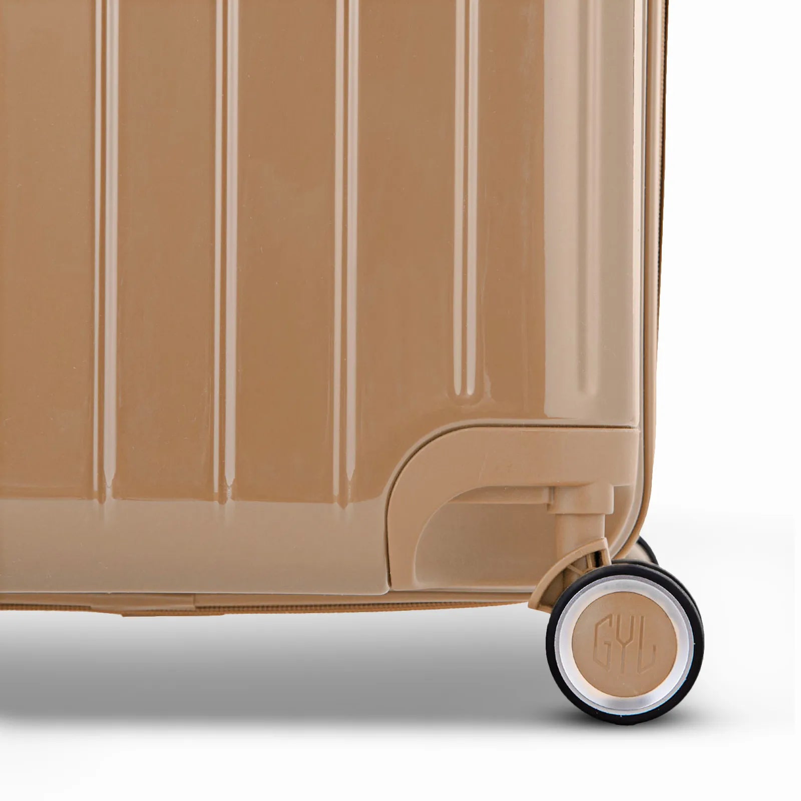 Détail de la roue et du logo GYL sur le bas de la valise trunk champagne en polycarbonate brillant.