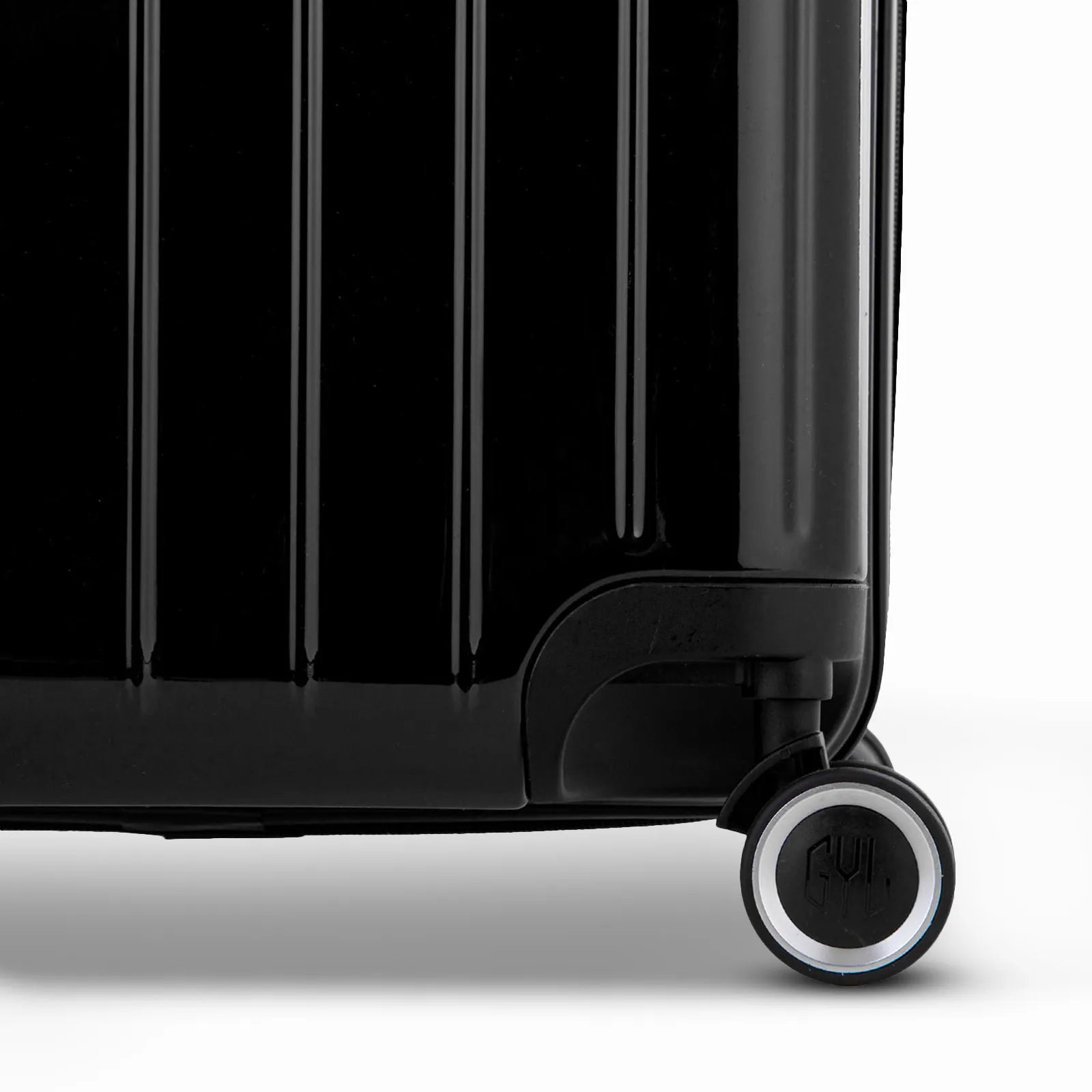Détail de la roue et du logo GYL sur le bas de la valise trunk noir en polycarbonate brillant.