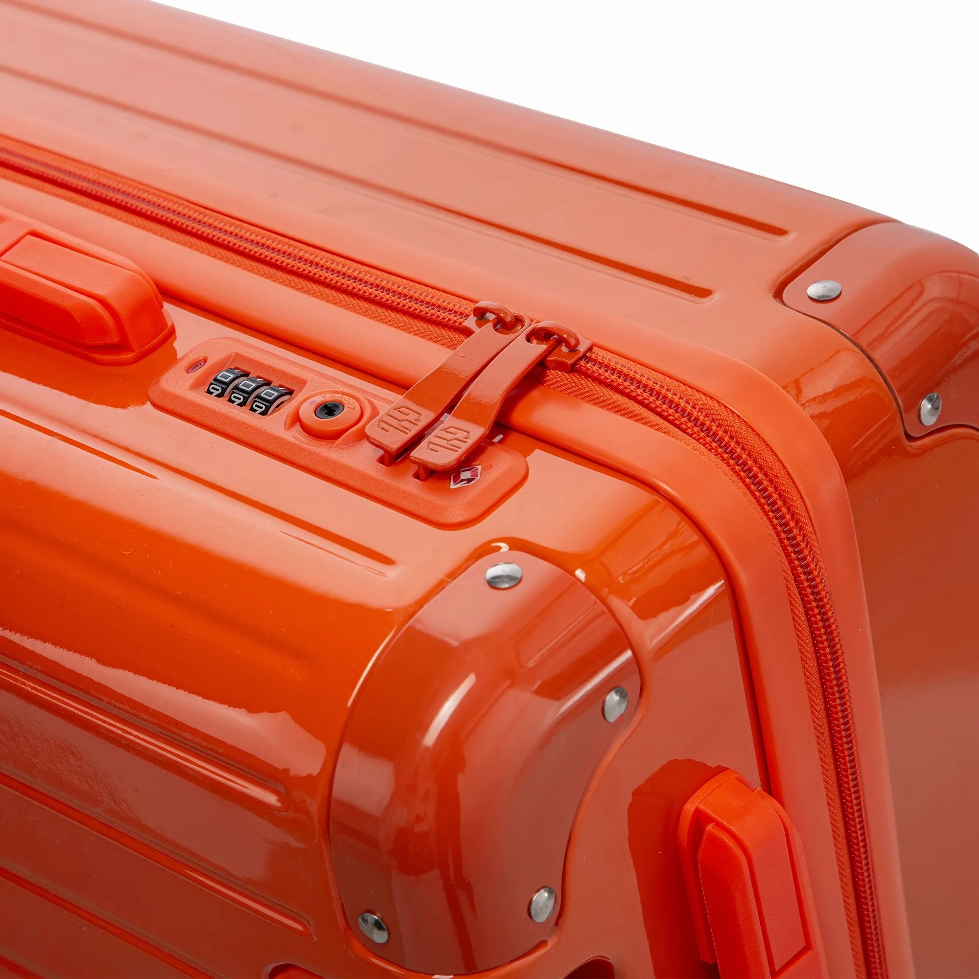Fermeture à combinaison TSA et double curseur zippé GYL sur la valise rigide orange Intemporelle.