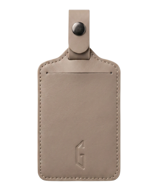 Etiquette de bagage GYL en cuir coloris champagne, porte-adresse avec logo G embosse et bouton pression metallique