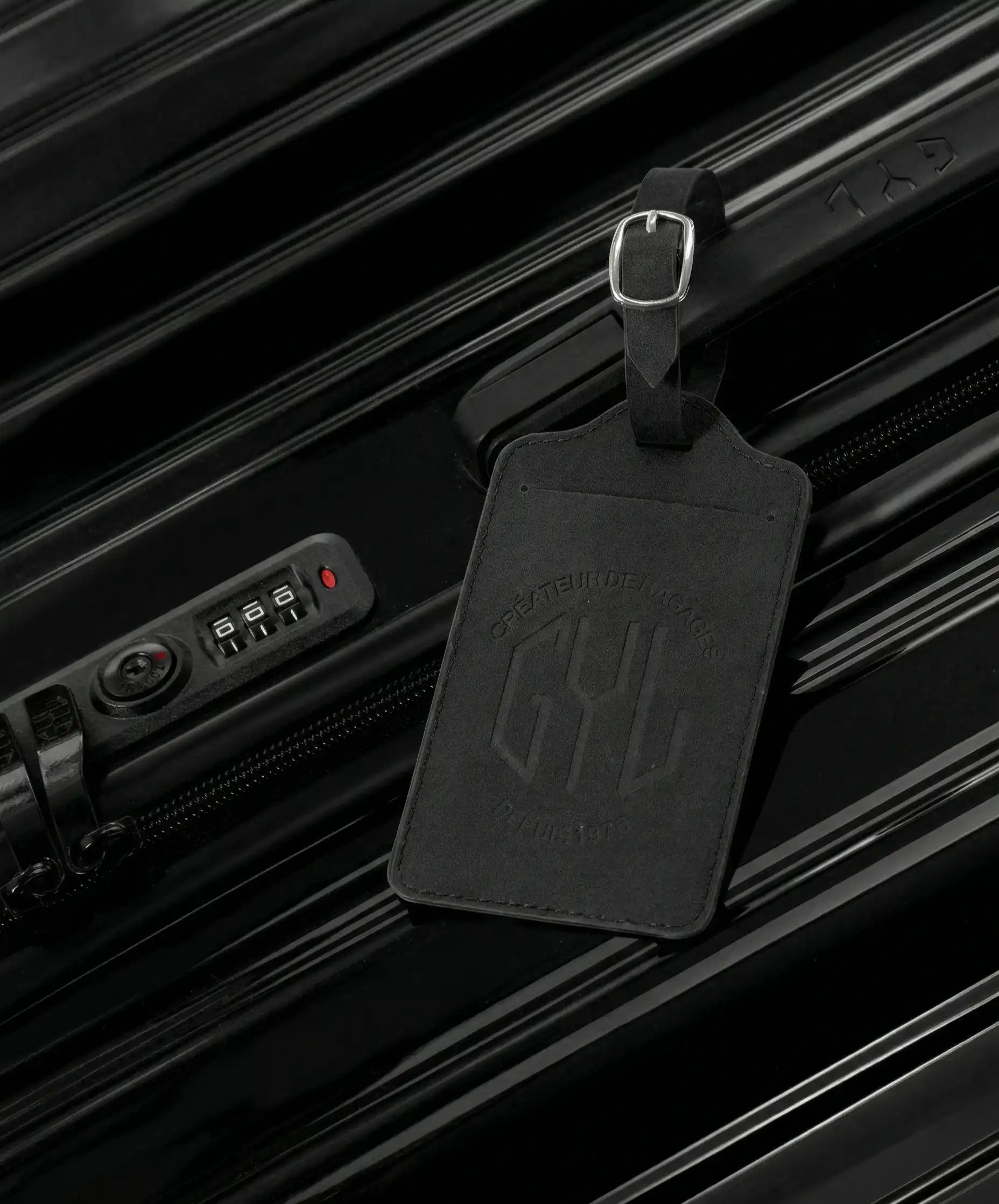 Etiquette a bagages GYL noire accrochee sur valise Intemporelle noire