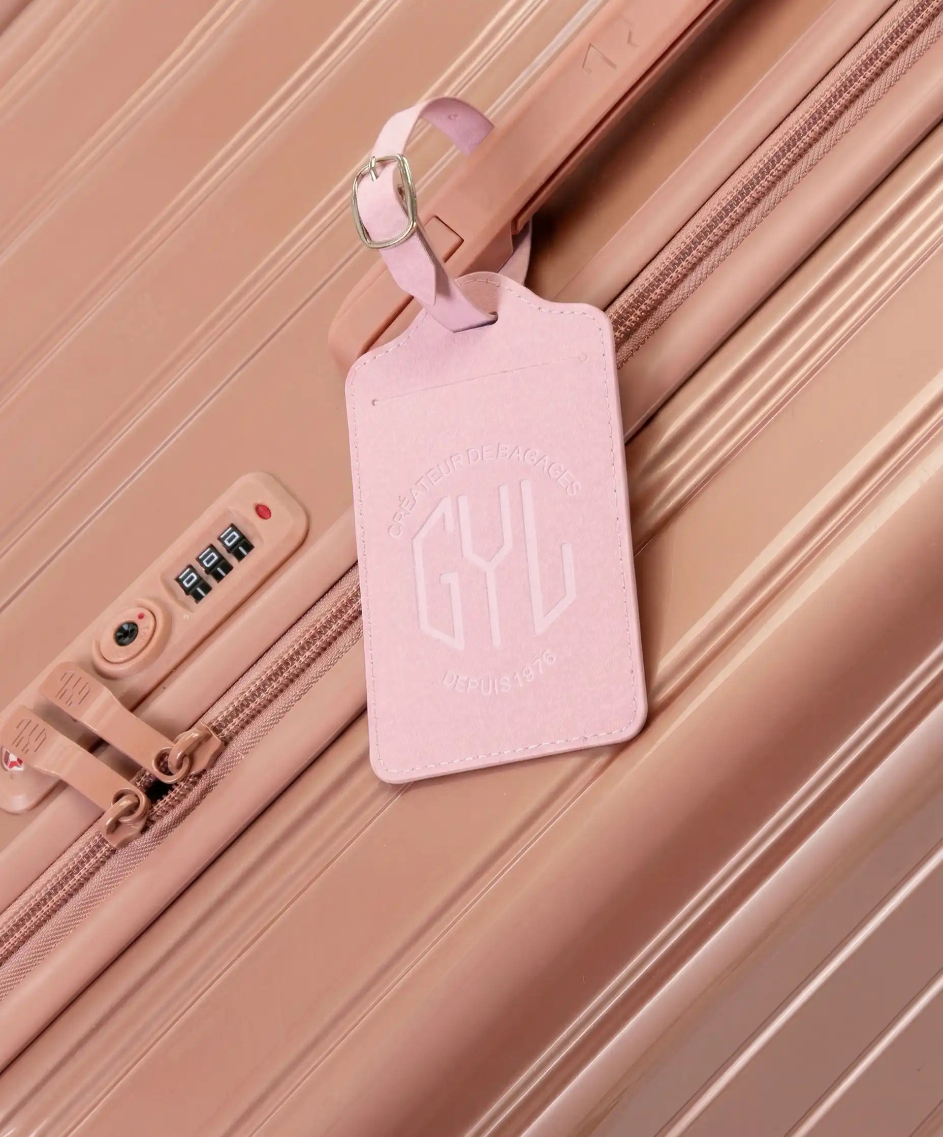 Etiquette a bagages GYL rose accrochee sur valise Intemporelle rose gold