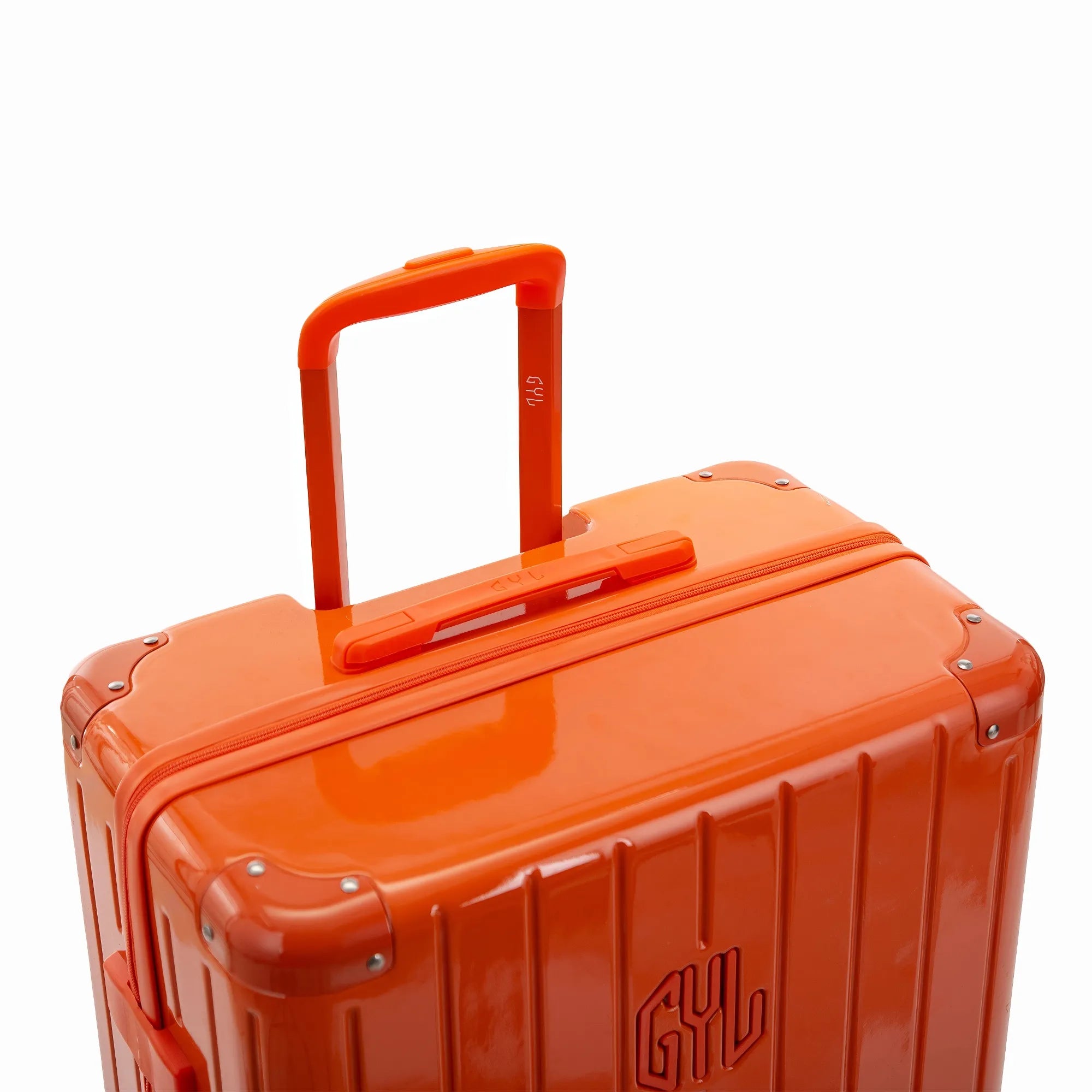 Poignée trolley télescopique GYL déployée sur la valise Intemporelle orange en polycarbonate.