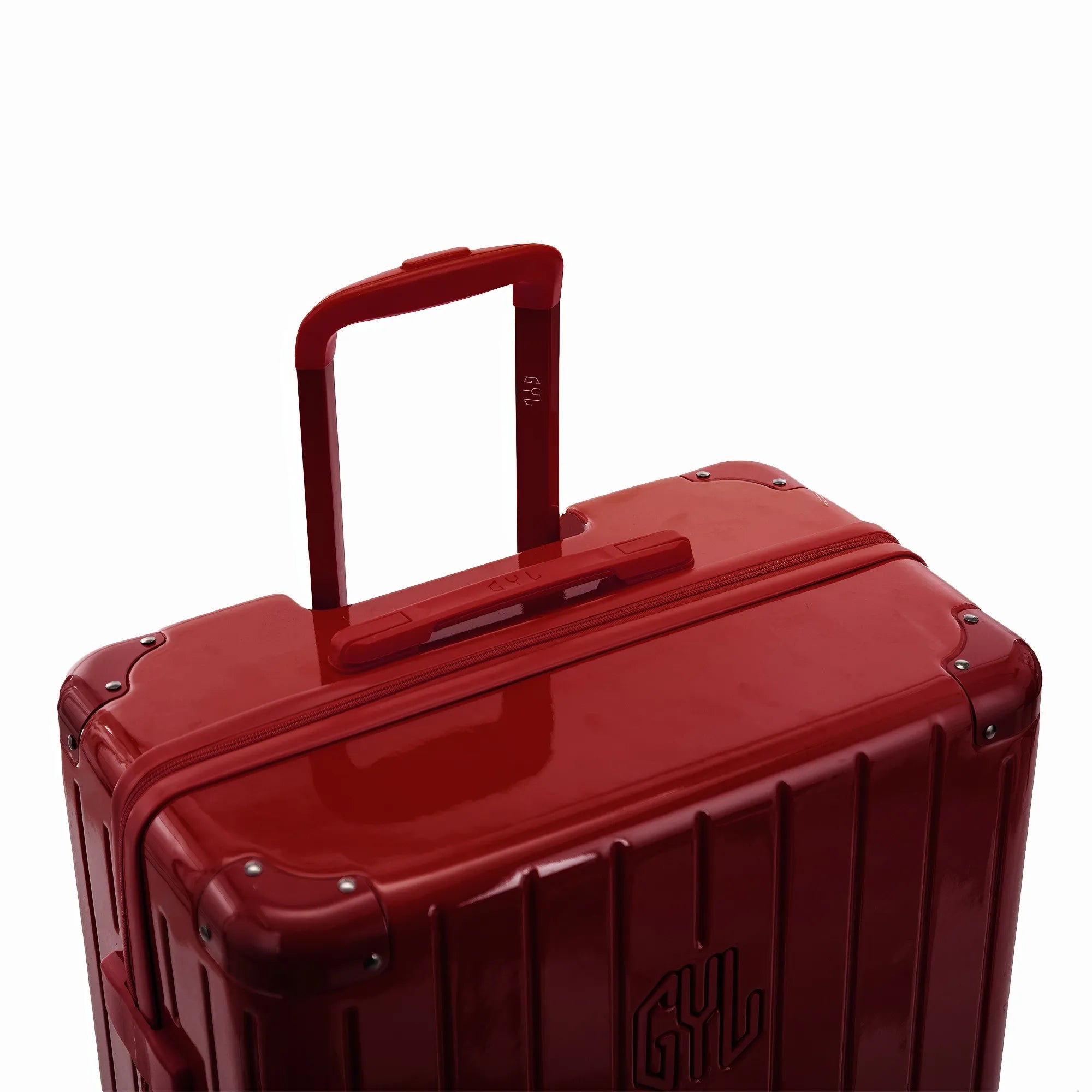 Poignée trolley télescopique GYL déployée sur la valise Intemporelle rouge foncé en polycarbonate.