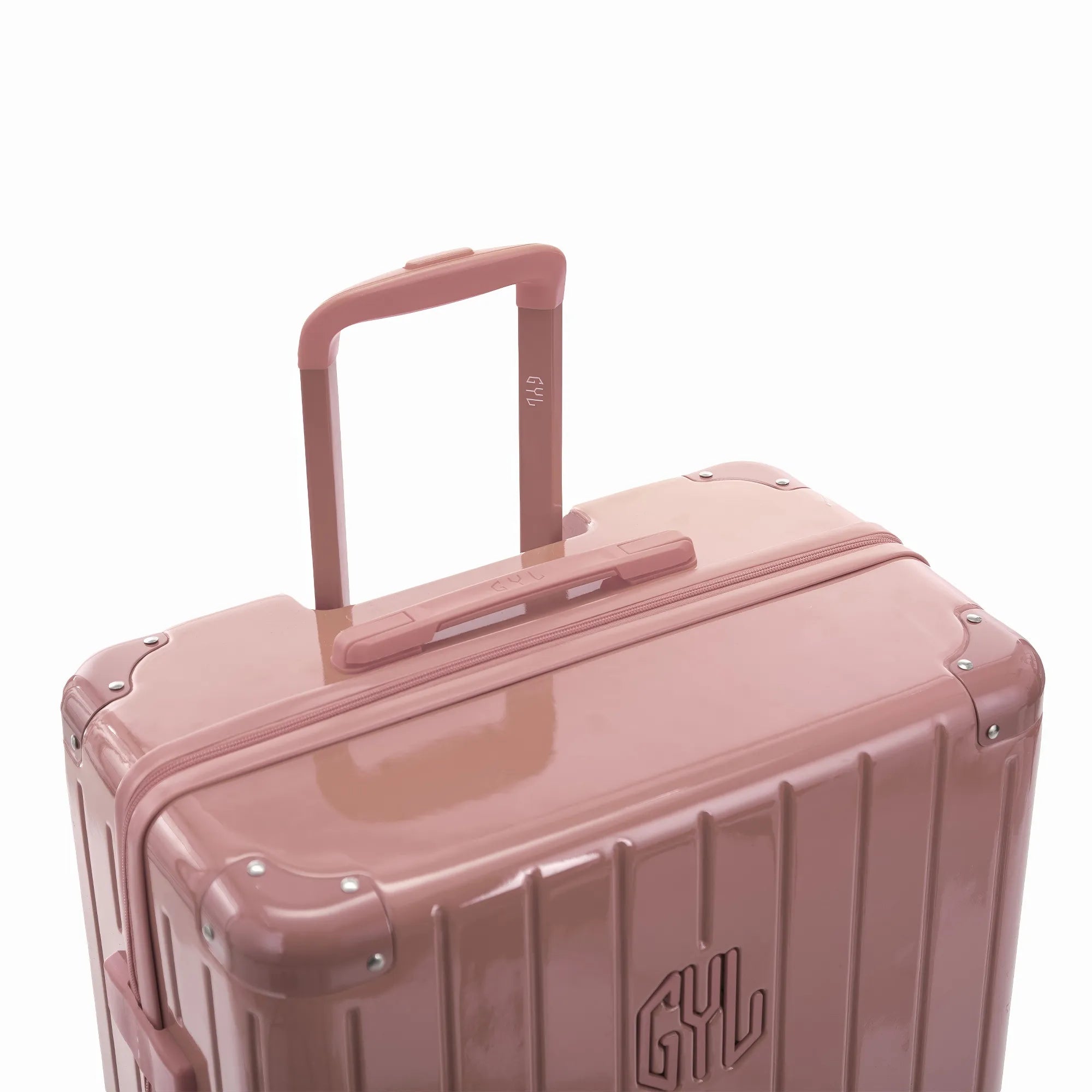 Poignée trolley télescopique GYL déployée sur la valise Intemporelle rose gold en polycarbonate.