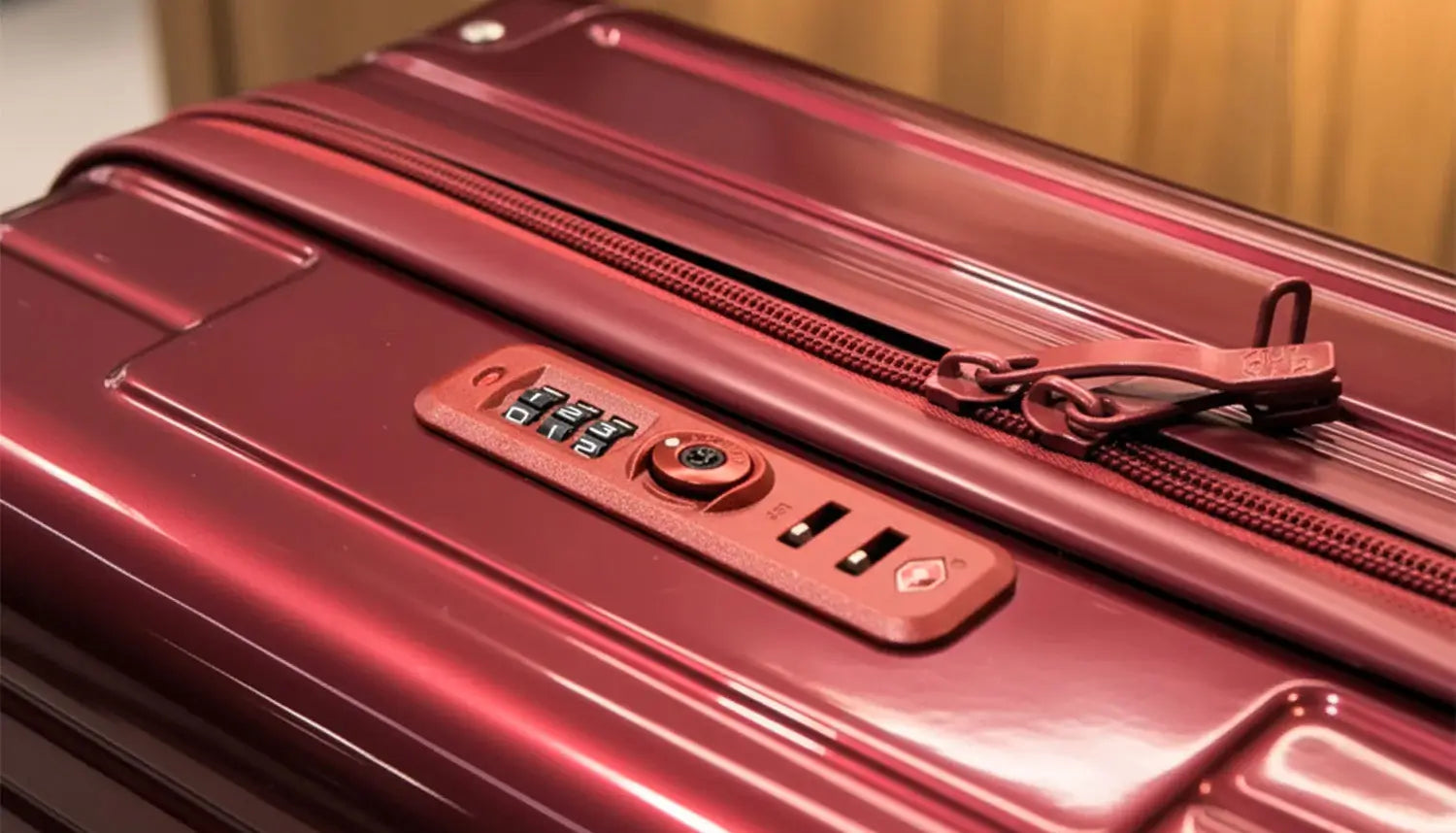Cadenas TSA d’une valise GYL rouge avant le changement de code, avec les curseurs non insérés dans la serrure