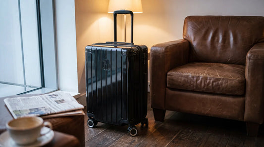 Valise cabine GYL Intemporelle noire dans un salon d'aéroport à Londres