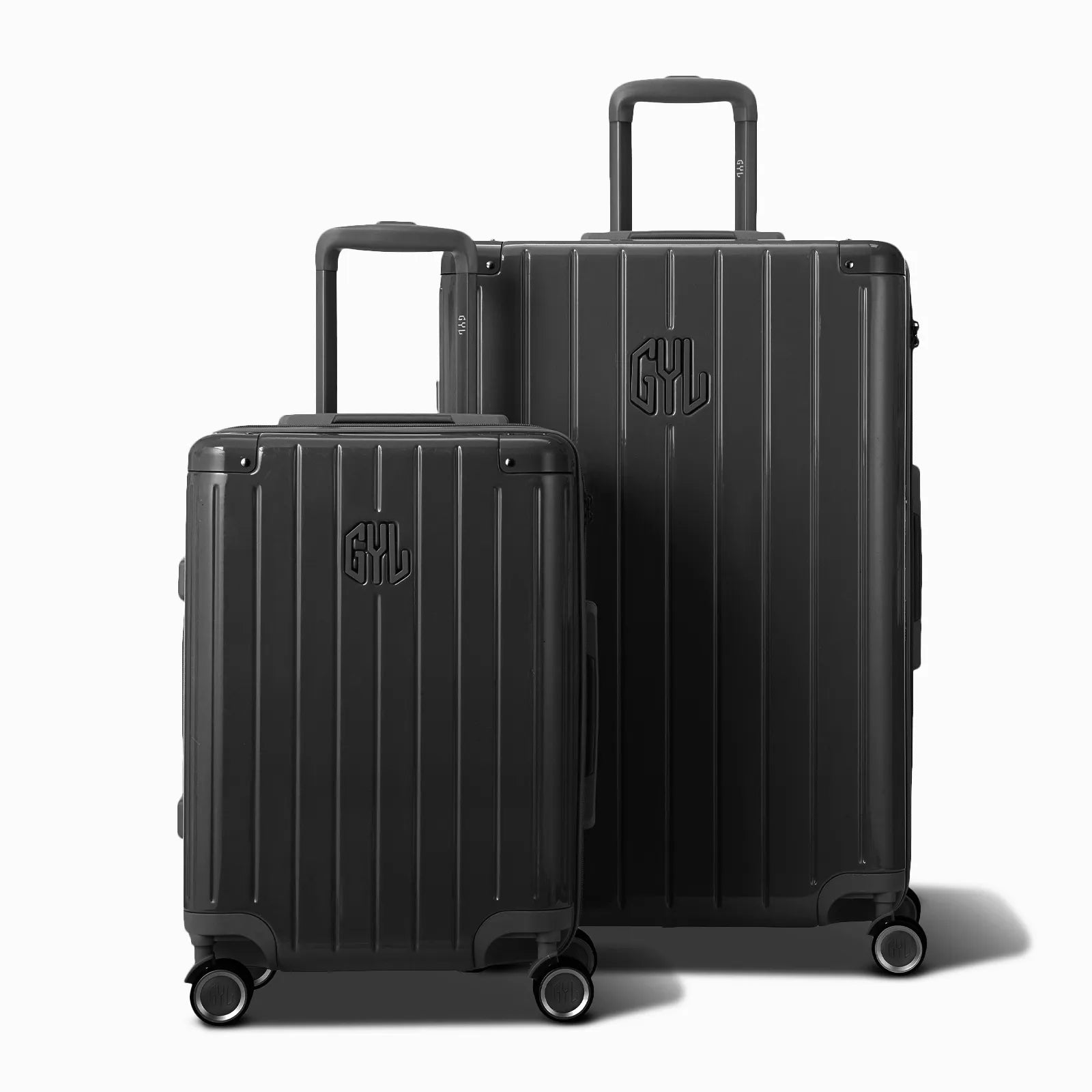 Deux valises rigides GYL Intemporelle gris foncé, format cabine et soute, avec poignée trolley déployée. #couleur_gris foncé