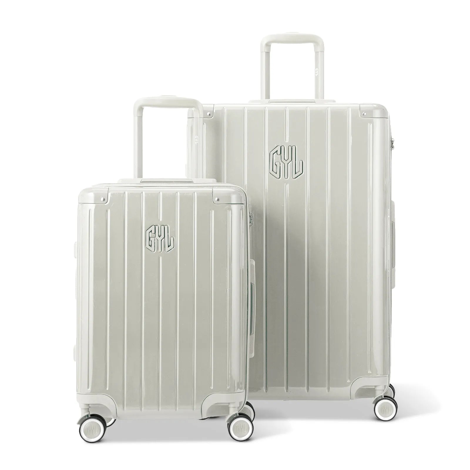 Deux valises rigides GYL Intemporelle sable, format cabine et soute, avec poignée trolley déployée.