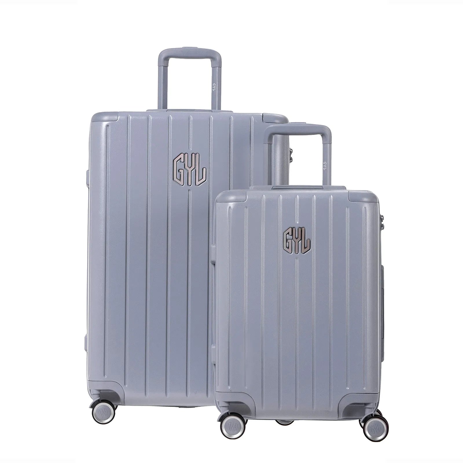 Deux valises rigides GYL Intemporelle argent, format cabine et soute, avec poignée trolley déployée.