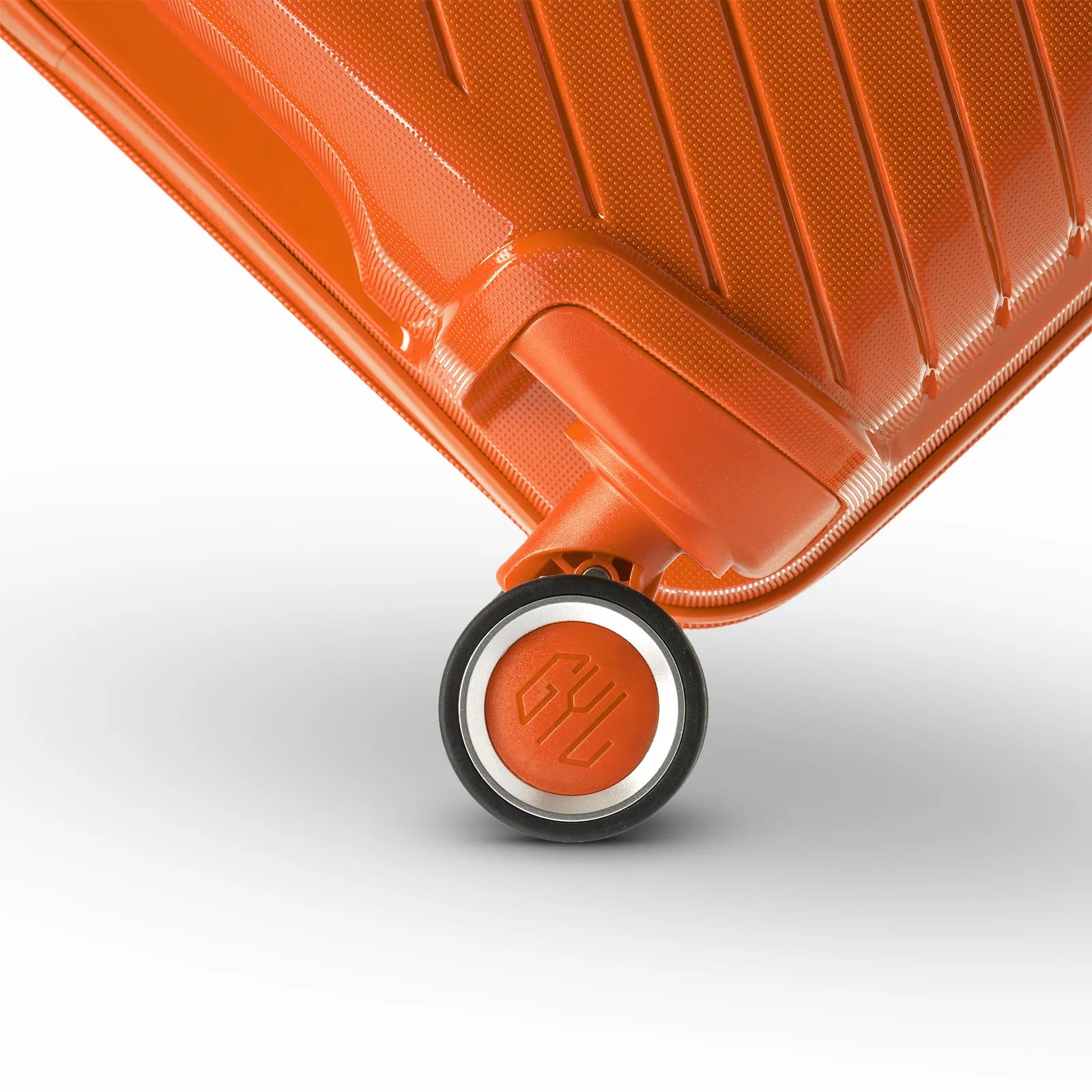 Détail de la roue avec logo GYL sur la valise Signature orange en polypropylène brillant.