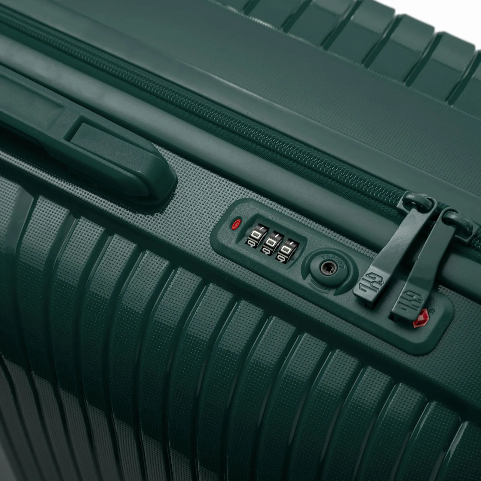 Détail de la serrure TSA intégrée et des curseurs sur la valise Signature sapin.