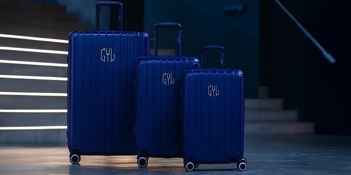 Set de 3 valises rigides GYL en polycarbonate bleu nuit, tailles cabine, moyenne et grande, avec roulettes multidirectionnelles et design élégant.