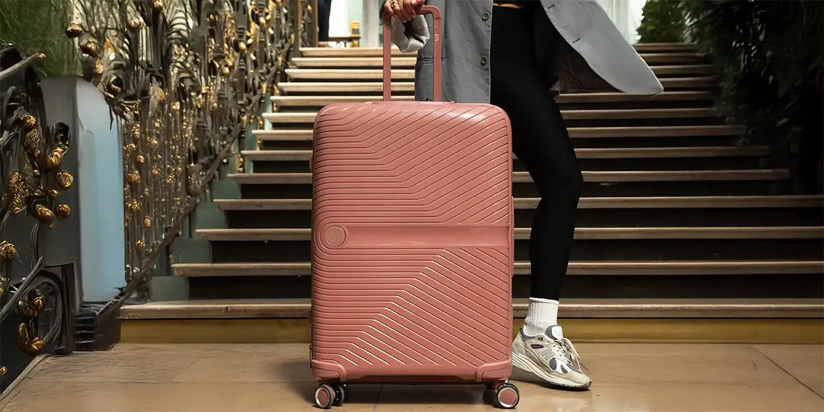 Grande valise rigide GYL en polycarbonate, modèle soute couleur rose poudré, avec quatre roulettes multidirectionnelles, idéale pour les longs voyages.