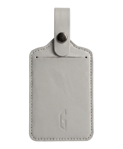 Etiquette de bagage GYL en cuir coloris gris argent, porte-adresse avec logo G embosse et bouton pression metallique