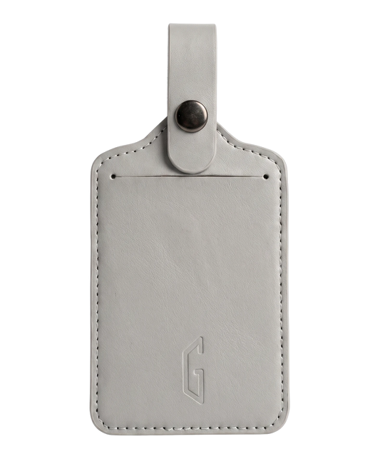 Etiquette de bagage GYL en cuir coloris gris argent, porte-adresse avec logo G embosse et bouton pression metallique