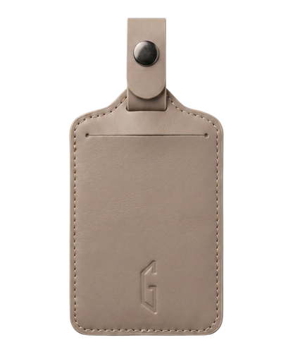 Etiquette de bagage GYL en cuir coloris champagne, porte-adresse avec logo G embosse et bouton pression metallique