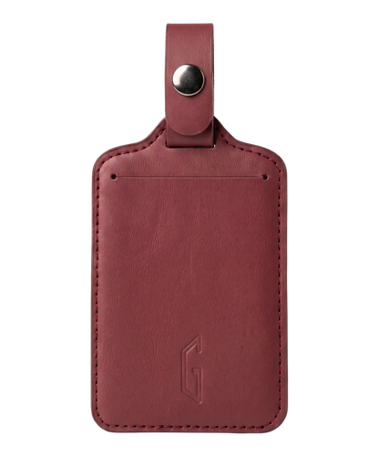 Etiquette de bagage GYL en cuir coloris rouge fonce, porte-adresse avec logo G embosse et bouton pression metallique