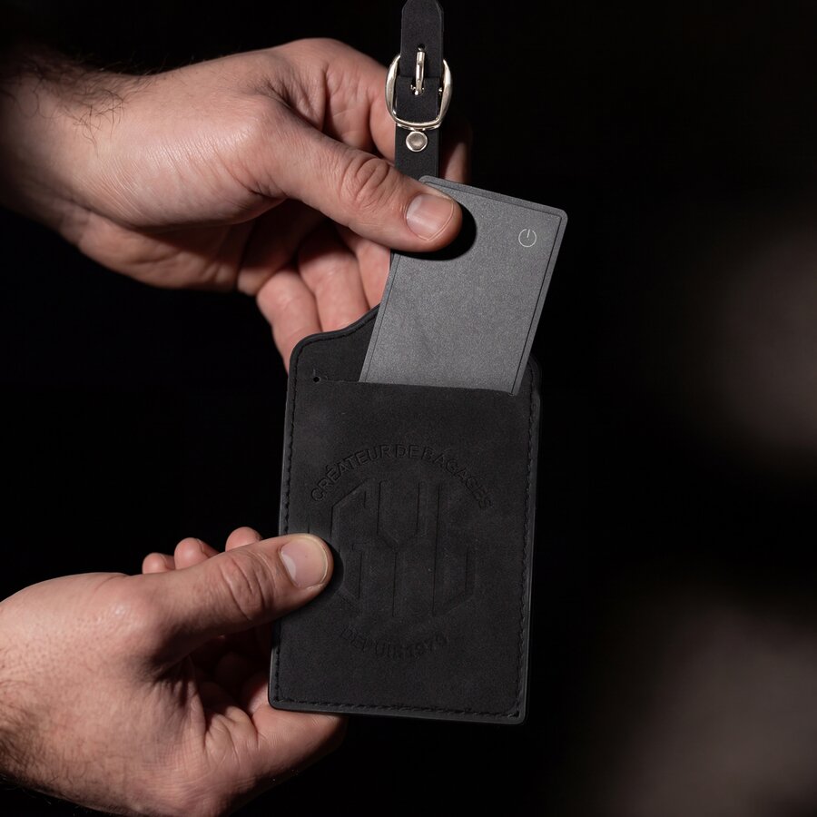 Tracker GYL glissé dans une étiquette bagage en cuir noir pour localiser sa valise