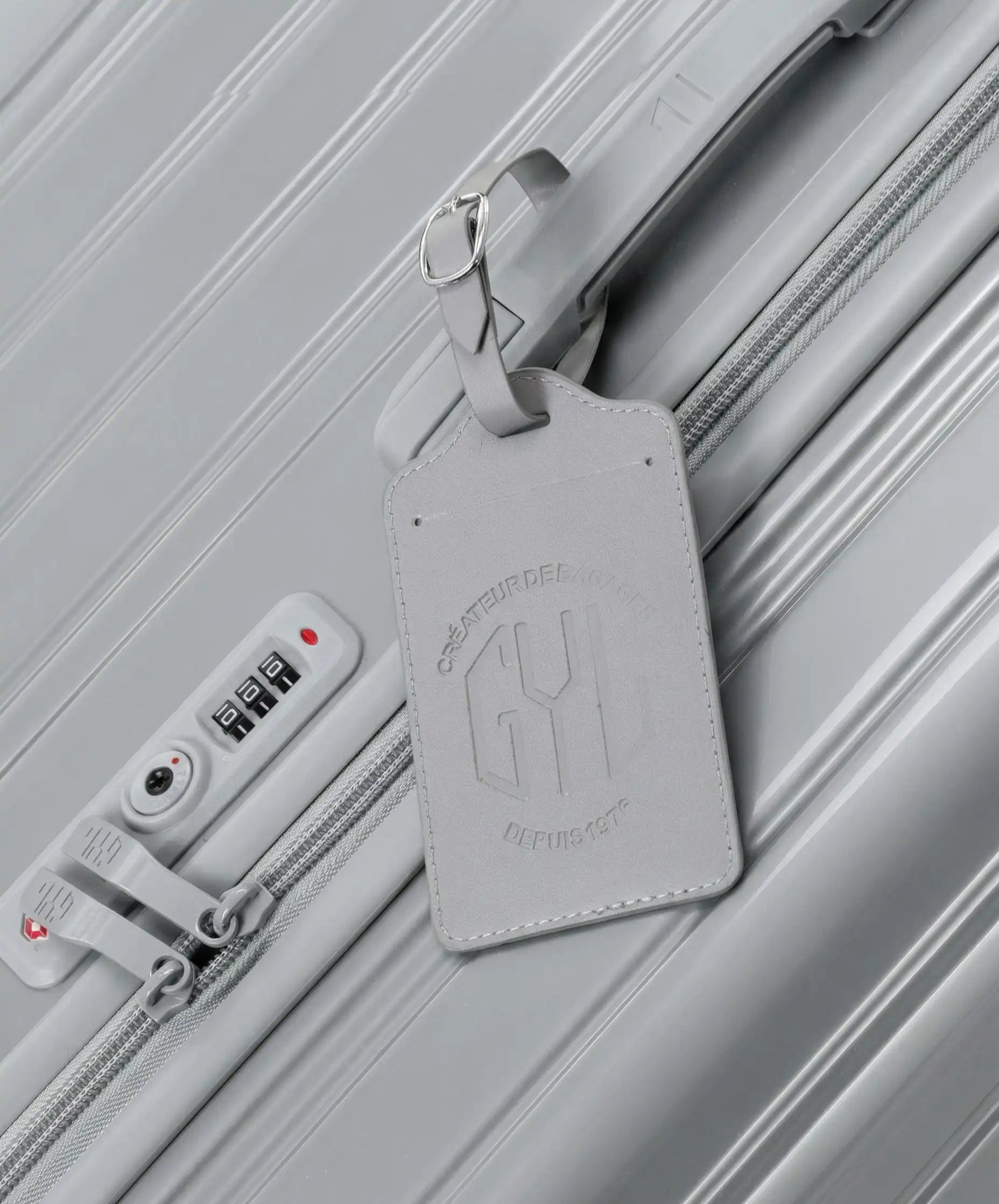 Etiquette a bagages GYL argent accrochee sur valise Intemporelle argent