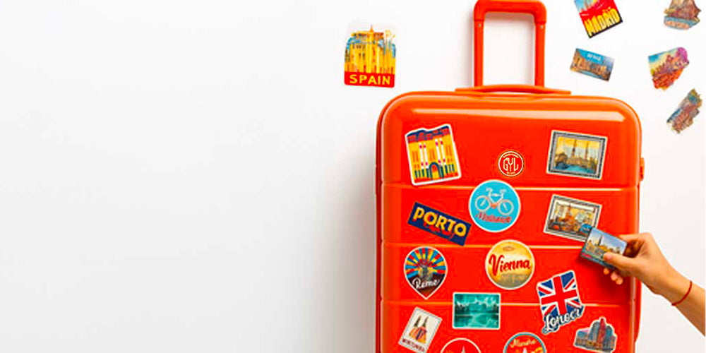 Valise rigide orange recouverte de stickers voyage colorés – autocollants décoratifs pour valises cabine, moyenne et soute.