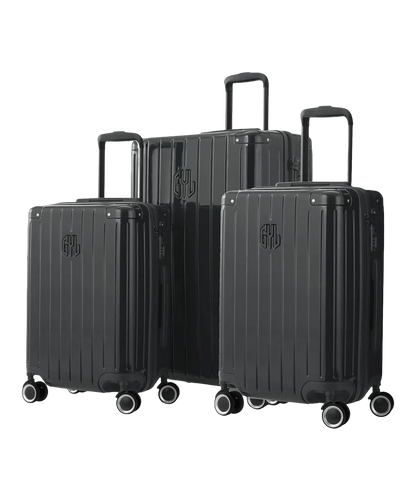 Set de 3 valises Intemporelle en polycarbonate cabine, semaine et soute coloris gris foncé glossy vue trois quarts avant avec trolleys télescopiques sortis et logo GYL, packshot GYL
