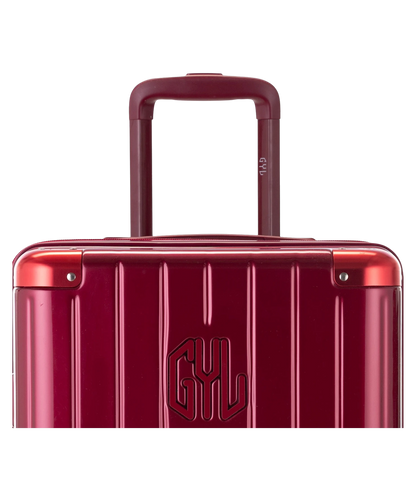 Valise Trunk L Intemporelle GYL en polycarbonate 71 cm coloris rouge fonce gros plan sur la poignee trolley et les coins renforces