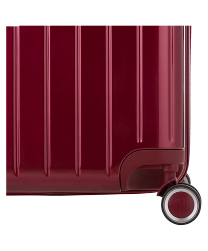 Valise Trunk L Intemporelle GYL en polycarbonate 71 cm coloris rouge fonce gros plan sur une roulette double 360 degres siglee GYL